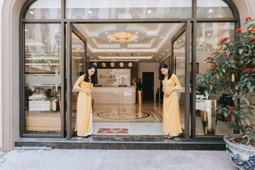 two women standing in front of a store window at Golden Sea Hotel in Ha Long