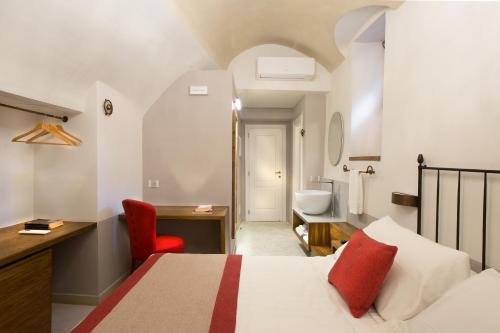 a hotel room with a bed and a desk and a bathroom at Dimora del Leone Gaeta in Gaeta