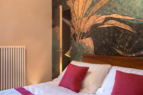 a bedroom with a bed with red and white pillows at Dimora del Leone Gaeta in Gaeta