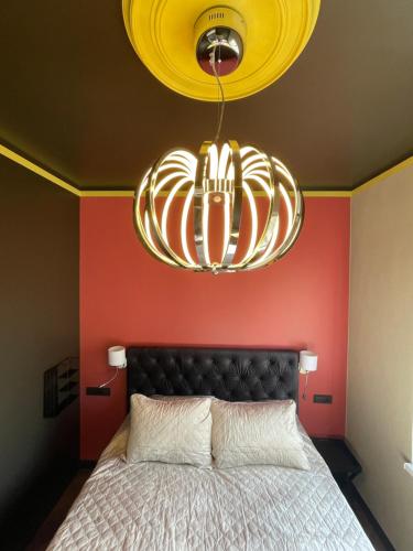 a large chandelier hanging over a bed in a room at Augšdzintari apartament in Saulkalne