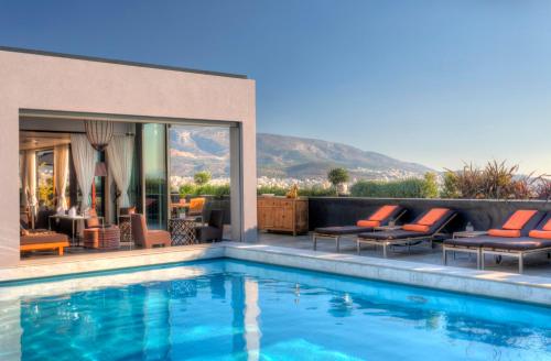 una piscina con tumbonas y una casa en President Hotel, en Atenas