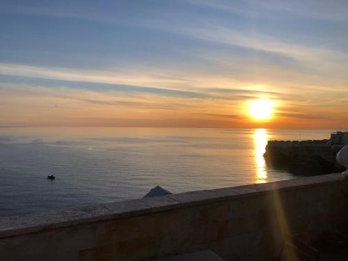 a sunset over the ocean with the sun in the sky at La Torretta del Senatore in Polignano a Mare