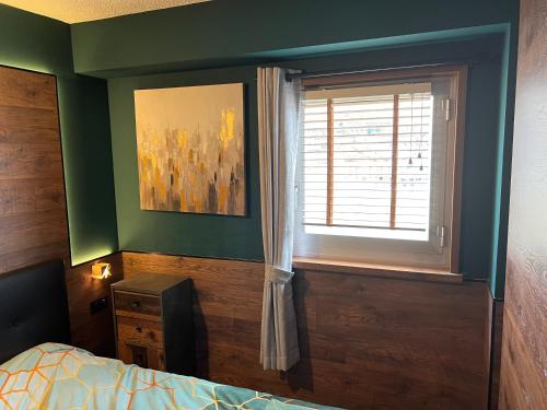 a bedroom with a window and a bed and a dresser at Suite il sogno di Grebek in Passo del Tonale