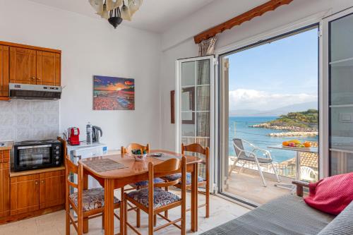 a kitchen with a table and a view of the ocean at Limani Apartments in Kassiopi