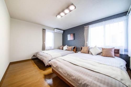 sypialnia z 2 łóżkami i oknem w obiekcie THE BEEHIVEⅠ w mieście Sapporo
