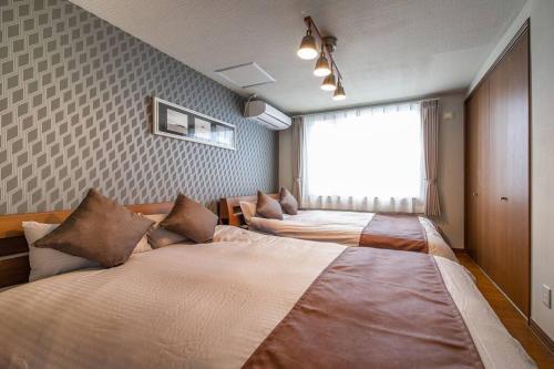 a room with two beds in it with a window at THE BEEHIVEⅠ in Sapporo