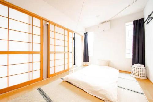 a bedroom with a bed and large windows at NUPURI in Otaru