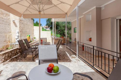 a patio with a table with fruit on it at Limani Apartments in Kassiopi