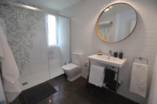 a bathroom with a toilet and a sink and a mirror at Apartamento 2 dormitorios con piscina y jardín - Apartamentos Montesomo in Somo