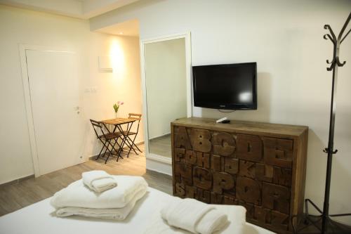a room with a television and towels on a bed at Bait Alfa Kibbutz Country Lodging in Bet Alfa