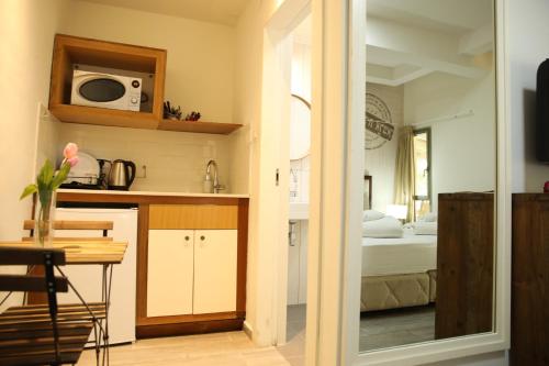 a room with a kitchen and a bedroom with a bed at Bait Alfa Kibbutz Country Lodging in Bet Alfa