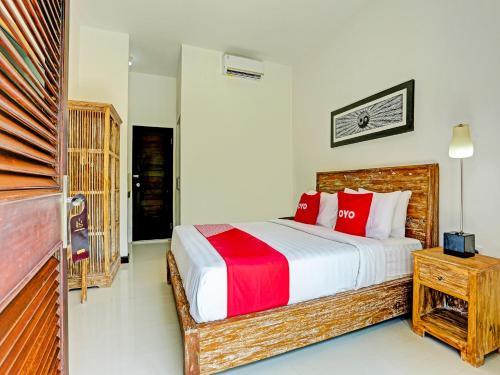 a bedroom with a large bed with red pillows at OYO 91123 Madhava 108 in Ungasan
