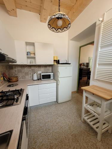 a kitchen with white cabinets and a table in it at Palazzo Fassitelli in Cossignano