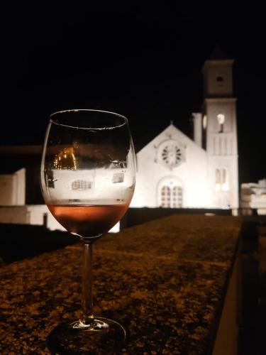 a glass of wine sitting on a table with a church at CASA ARCO BIANCO in Giovinazzo