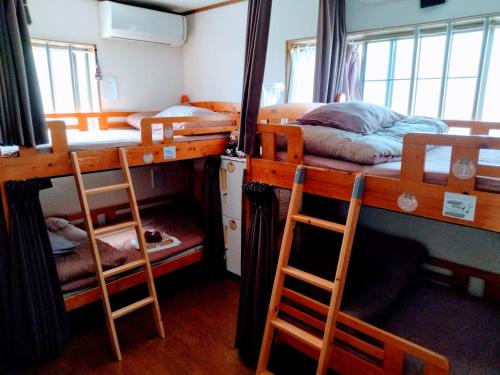 1 dormitorio con 2 literas y 2 sillas en Osaka Tomato Guesthouse en Osaka