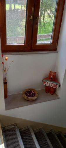 a window sill with a pizza and a teddy bear on it at Casa de oaspeti Kinga's Crown in Băile Tuşnad