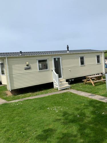 a mobile home with a porch and a picnic table at Newquay Bay Resort 63 in Newquay Bay Resort