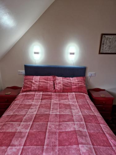 a bedroom with a large bed with a pink blanket at Creag Meggan in Ballater