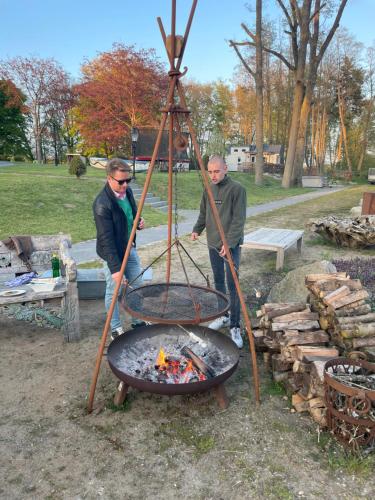 two men standing next to a fire pit at Herrenhaus Gut Neuruppersdorf in Timmendorfer Strand