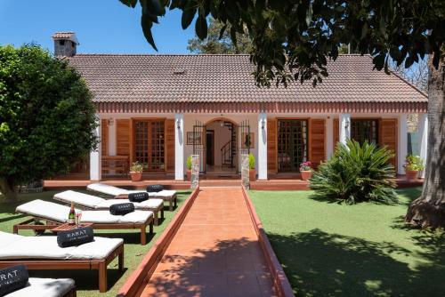 un edificio con una fila de tumbonas en un patio en KARAT Villa Fernanda, en Tacoronte