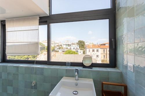Un baño con lavabo y una gran ventana. en HORIZON MER - Splendide vue Mer et îles, en Marsella