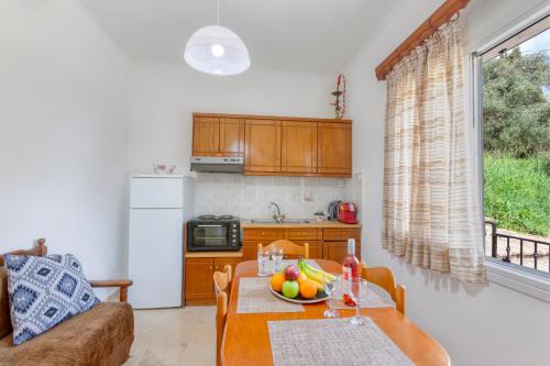 a kitchen with a table with a bowl of fruit on it at Limani Apartments in Kassiopi