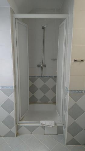 a shower with a glass door in a bathroom at Hotel Napsugár in Balatonmáriafürdő