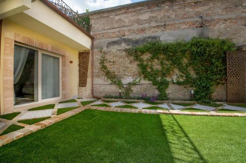 a garden with green grass next to a building at B&B Le Casette Chieti in Chieti