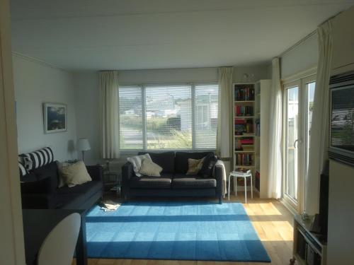 sala de estar con sofá y ventana grande en De Boomhut en Buren