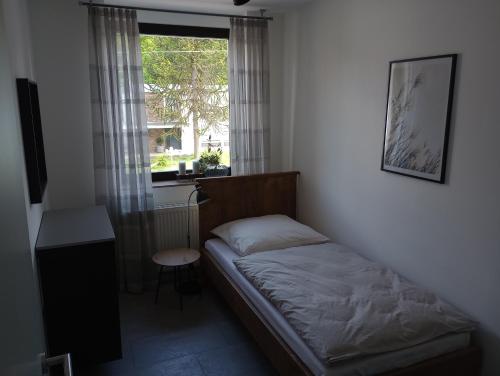 um pequeno quarto com uma cama e uma janela em Provizial Ferienwohnung Rudi em Wadgassen