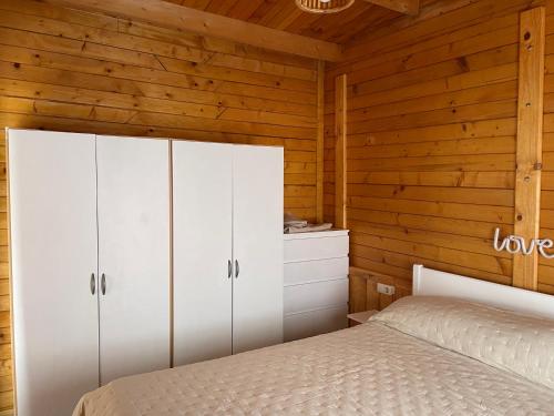 - une chambre avec des placards blancs et un lit dans l'établissement Agradable Mini Casa de madera con jardín amplio, à La Laguna