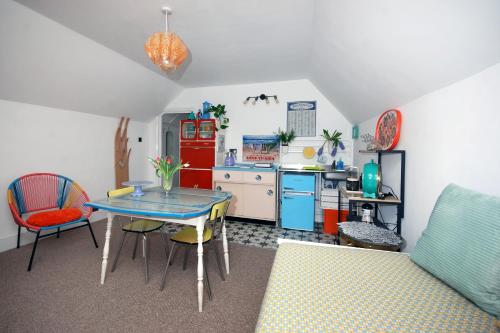 a kitchen with a table and a kitchen with a refrigerator at Enjoy Ventnor 2, Pier Street, Wightlink offer in Ventnor