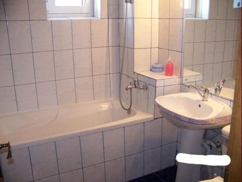 un bagno con un lavandino, una vasca da bagno e un lavandino di Apartament Zippi Republicii RHBM a Baia Mare