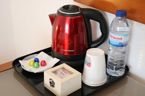 a black tray with a coffee maker and a bottle of water at Hotel Solar das Laranjeiras in Vale de Cambra