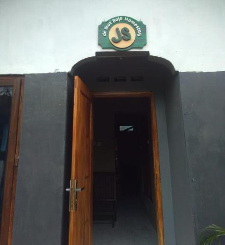 a door with a sign on top of a building at De Ikut Bojo Homestay in Magelang