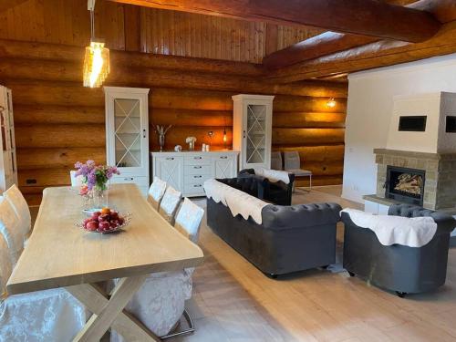 a living room with a table and chairs and a fireplace at Traumhaftes Blockhaus am Rhein in Kamp-Bornhofen