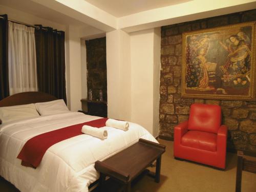 una camera da letto con un letto e una sedia rossa di Hotel Montecristo Cusco a Cuzco