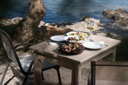 a table with two plates of food and a glass of wine at Mylos Seaside Experience in Frangokastello