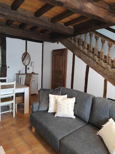 a living room with a couch and a table at Le Doux Rivage, proche de Charleville, jardin et accès à la voie verte in Joigny-sur-Meuse