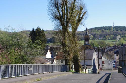 a street in a town with a fence and a church at Le Doux Rivage, proche de Charleville, jardin et accès à la voie verte in Joigny-sur-Meuse