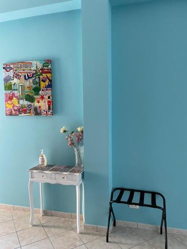 a table and a chair next to a blue wall at Esmeralda Apartment in Palermo