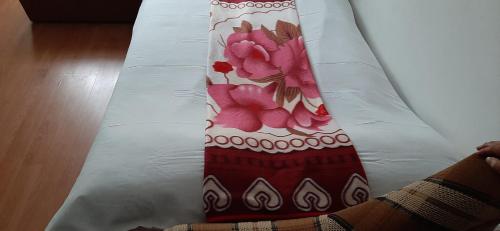 eine Person, die auf einem Bett mit einer roten und weißen Krawatte liegt in der Unterkunft Apartament Lucica in Mangalia