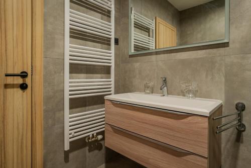 Maestro - Rooms & Resturant في فوكوفار: حمام مع حوض ومرآة