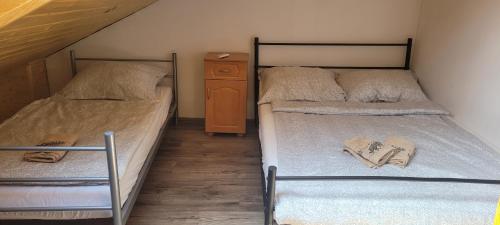 two twin beds in a room with a wooden floor at Noclegi u Eli Zator Energylandia in Zator