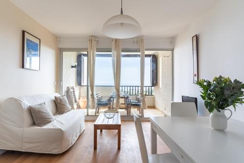 un salon avec un canapé blanc et une table dans l'établissement TERRE MARINE - Bel appartement avec terrasse vue mer, à Cassis