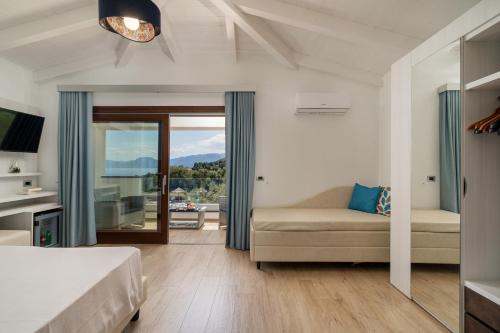 una camera con letto, divano e finestra di I Ginepri Hotel a Cala Gonone