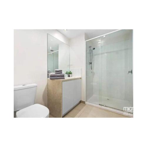 a bathroom with a toilet and a glass shower at Lovely apartment in Melbourne