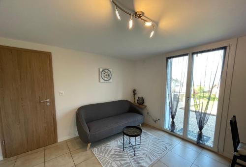 a living room with a couch and a sliding glass door at Studio Terrasse Vue Lac Entrée indépendante in Font