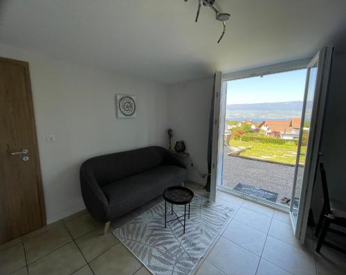 a living room with a couch and a sliding glass door at Studio Terrasse Vue Lac Entrée indépendante in Font