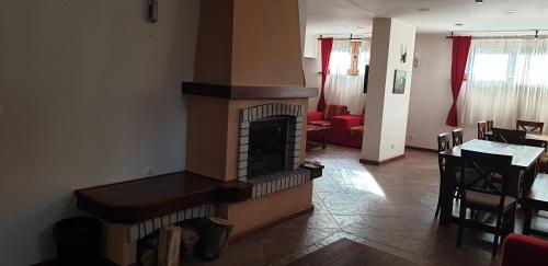 a living room with a fireplace and a dining room at Free SPA в Св. Иван Рилски - Сладък дом сред лукс in Bansko